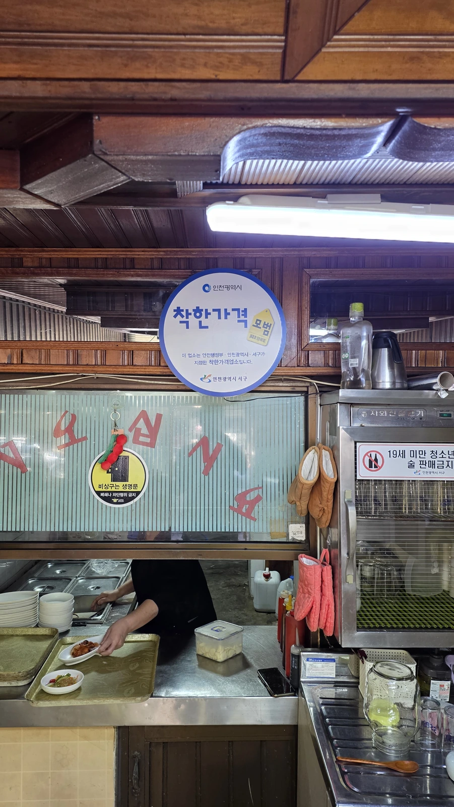 An Incheon and Seo-gu Good Price Business sign hanging by the kitchen