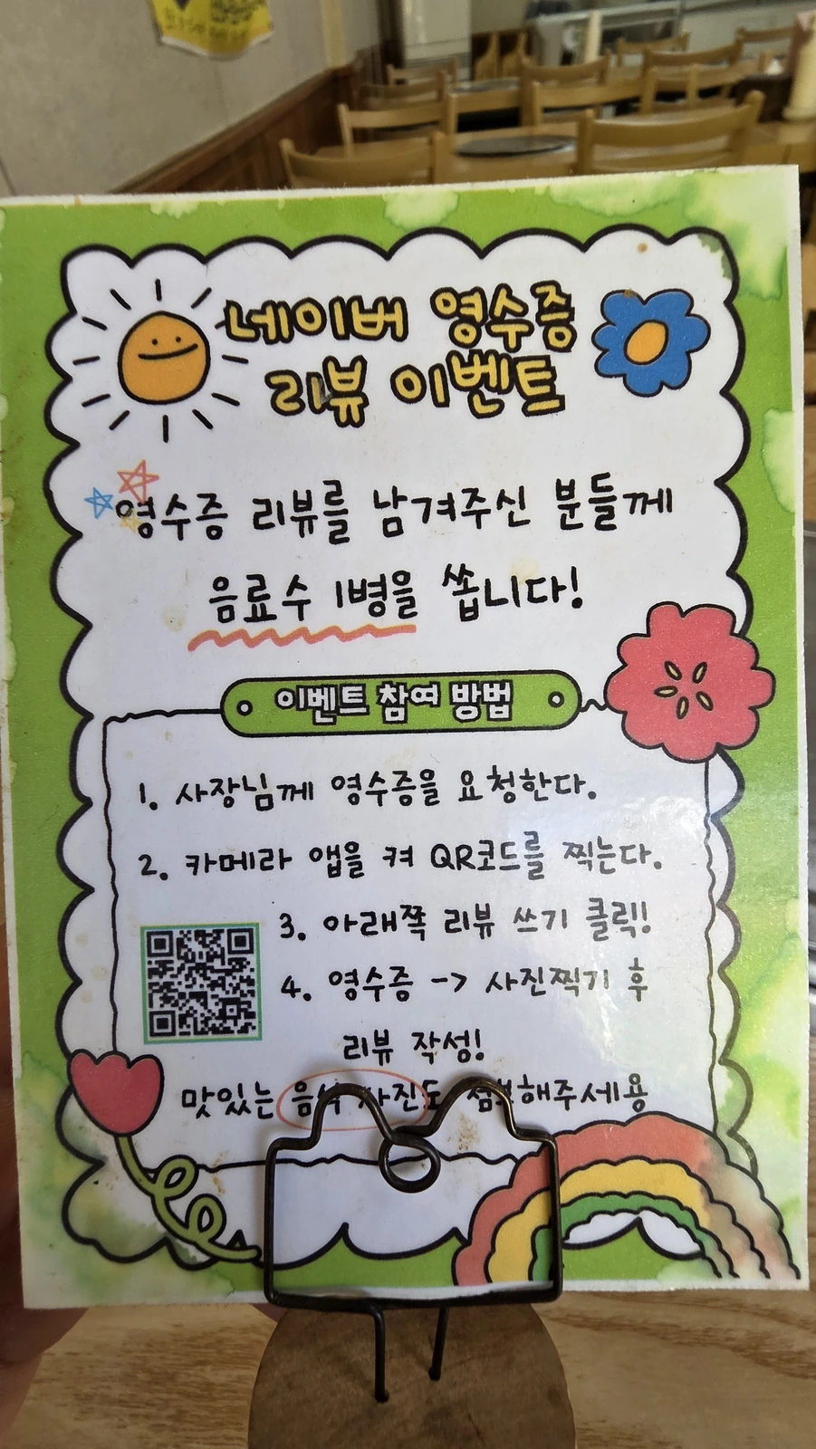 A restaurant promotion notice stating that a Naver receipt review earns one drink